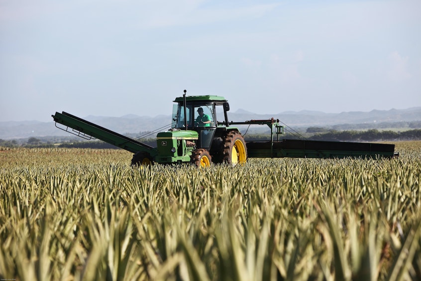 man driving a tractor through a fied meant to illustrate how farm equipment is often considered as collateral